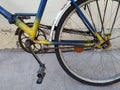 Fragment of an old bicycle painted in yellow, blue