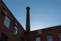 A fragment of an old brick factory building with a pipe