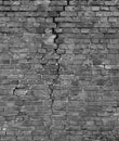 Fragment of an old brick wall of a building with a crack, black and white texture