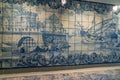 Fragment of old building wall with glazed ceramic white tiles, with blue painted scene. Traditional Portuguese architecture herita