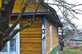Fragment of old cracked country wooden house wall painted in yellow and blue, with windows, old village of Belarus Royalty Free Stock Photo