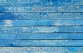 Fragment of an old fence. Cracked azure paint texture. Light blue wooden planks background.