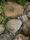 Fragment. abstract background, texture - an old road paved with natural wild glacial stone, overgrown with grass and moss. Royalty Free Stock Photo