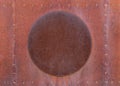 Fragment of old rusty unpainted metal surface with round plate in the middle. Textured background.