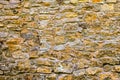 Fragment of old stone wall. Multicolored large cobbles in sunlight. Seamless texture of medieval stone wall