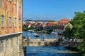 Fragment of the Old Town Hall with frescoes that adorn the facades, bridge over the river Regnitz and ancient houses on the banks