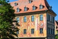 Fragment of the Old Town Hall with frescoes that adorn the facades with trompe d`oeil architecture on the bridge over the river