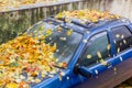 Fragment of old used car covered with wet fallen leaves