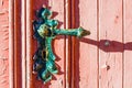 old weather-beaten red door with old vintage door knob, surface with chapped textured paint
