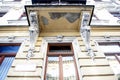 Fragment of an old window and a balcony with caryatids.