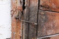 A Fragment Of An Old Wooden Door Made Of Boards Covered With Peeling And Cracked Green Paint. The Door Has A Handle, Latch And