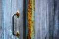 Fragment of an old wooden door with a rusty metal handle. Village gate, close-up Royalty Free Stock Photo