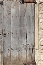 Fragment of an old wooden door in a stone house. Royalty Free Stock Photo