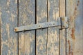 A fragment of an old wooden gate with remnants of blue paint and rusty hinges Royalty Free Stock Photo