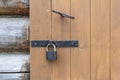 A fragment of an old wooden hut with a door. An old wooden door for entering and exiting the house,locked with a padlock Royalty Free Stock Photo
