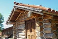 Fragment of old, worn brown tile roof on the right of house