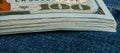 Fragment of a pack of hundred dollar bills. Extremely close-up. Denim as a background