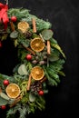 fragment photo of bright wreath decorated with dry orange slices balls and ribbon Royalty Free Stock Photo