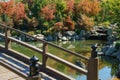 Fragment of picturesque wooden pedestrian bridge across large lake Oike in Japanese garden. Public landscape park Royalty Free Stock Photo