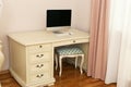 fragment of pink bedroom white wooden computer table with curtain, tulle closeup photo