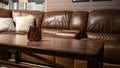 Fragment of private cabinet with brown leather sofa and massive wooden tea table Royalty Free Stock Photo