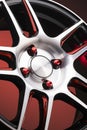 a fragment of red alloy wheels, spokes, wheel nuts and details of a sports car wheel close-up on a red background , a