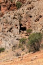 Entrance to a cave in the middle of a red rock in the mountains of Armenia. Royalty Free Stock Photo