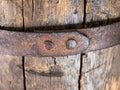 Fragment of a riveted metal hoop on an old wooden barrel