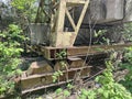 Fragment of a rusty crane. Green plants