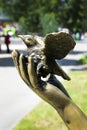 Fragment of sculpture, a bird in the hand of a man.
