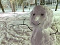 Fragment of a snowman, bust portrait. Hands from branches, eyes from cones and a smile.