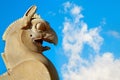 Fragment of stone column sculpture of a Griffin in Persepolis against a blue sky with clouds. Ancient Achaemenid Kingdom. Iran.