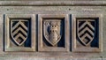 A fragment of a stone fence, a decorative element with a relief image of three shields, one depicts a tower