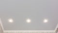 Fragment of the stretch ceiling with three spotlights in a row Royalty Free Stock Photo