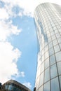 Fragment of a stylish modern high-rise building in St. Petersburg against the blue sky with clouds. The building has a glazed