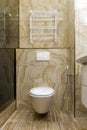 Fragment of a toilet with a natural stone finish. Interior design of a bathroom in yellow and white