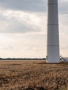 Fragment of tower of Eletric power generator wind turbine with rotating blades at sunset against cloudy sky. Close-up. Adyghe wind