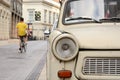 Fragment of Trabant car, bicyclist riding away