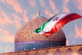 Fragment of traditional Iranian architecture and Iran`s national flag against the backdrop of sunset. Islamic national image