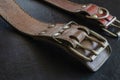 Fragment of two old genuine leather collars on a dark table