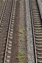 Fragment of two parallel railroad tracks lying on on railway ballast bed made of gravel. Top view from the bridge