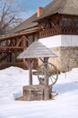 Fragment of a village courtyard with a wooden well and a house in the National Village Museum. Bucharest, Romania