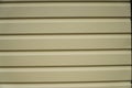 A fragment of a wall made of beige metal siding Royalty Free Stock Photo