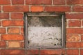 Fragment of the wall of an old house with a bricklaying of red brick and concreted a small window in the center Royalty Free Stock Photo