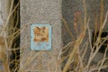 A fragment of a wall with an old Soviet inscription among the branches. Royalty Free Stock Photo