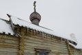 Fragment of a wall of an old wooden orthodox church and a roof with icicles. Royalty Free Stock Photo