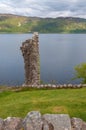 Fragment of a wall of the ruins of Urquhart Castle with Loch Ness behind