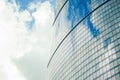 Fragment of a wall of a skyscraper with mirror glass against a sky with clouds. Royalty Free Stock Photo