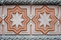 A fragment of a wall trimmed with carved multi-colored tiles with eight-pointed stars Royalty Free Stock Photo