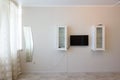 Fragment of the wall by the window in the bedroom interior, TV and wall cabinets